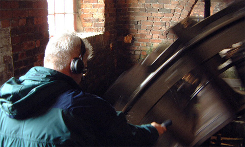 Photograph of Bill Fontana: image of Bill Fontana making a sound recording of a water wheel