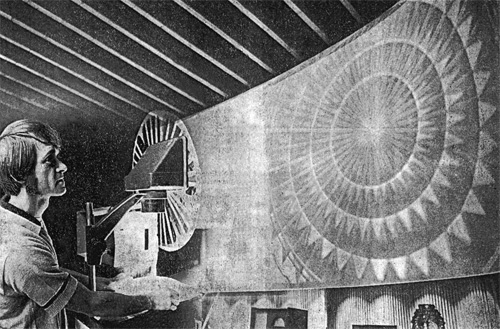 Photograph of Don Paulson from the 60s as he projects light onto a screen through a rotating disk mask