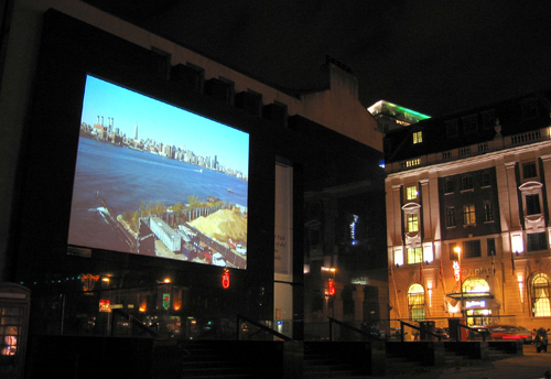 Photograph of the Henry Moore Institute building in Leeds with a live image of Manhattan projected onto the facade.